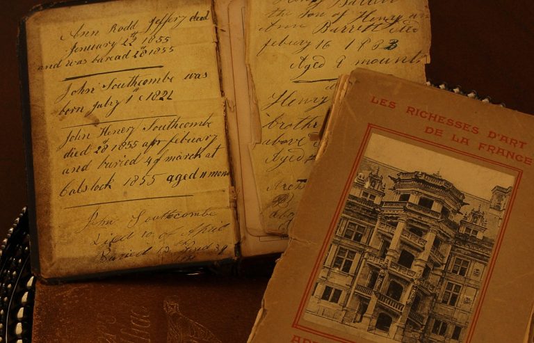 A close-up of a weathered, 19th-century leather-bound book titled Les Richesses D'art De La France, featuring handwritten ink notes on the inside cover and aged, yellowed pages.